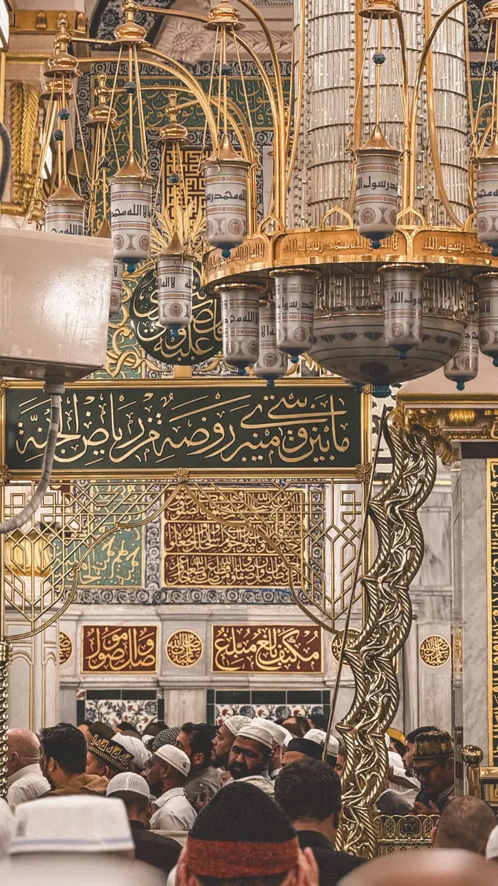 Inside Al-Masjid an-Nabawi — gilded calligraphy and chandeliers above the Riyadh al-Jannah in Madina
